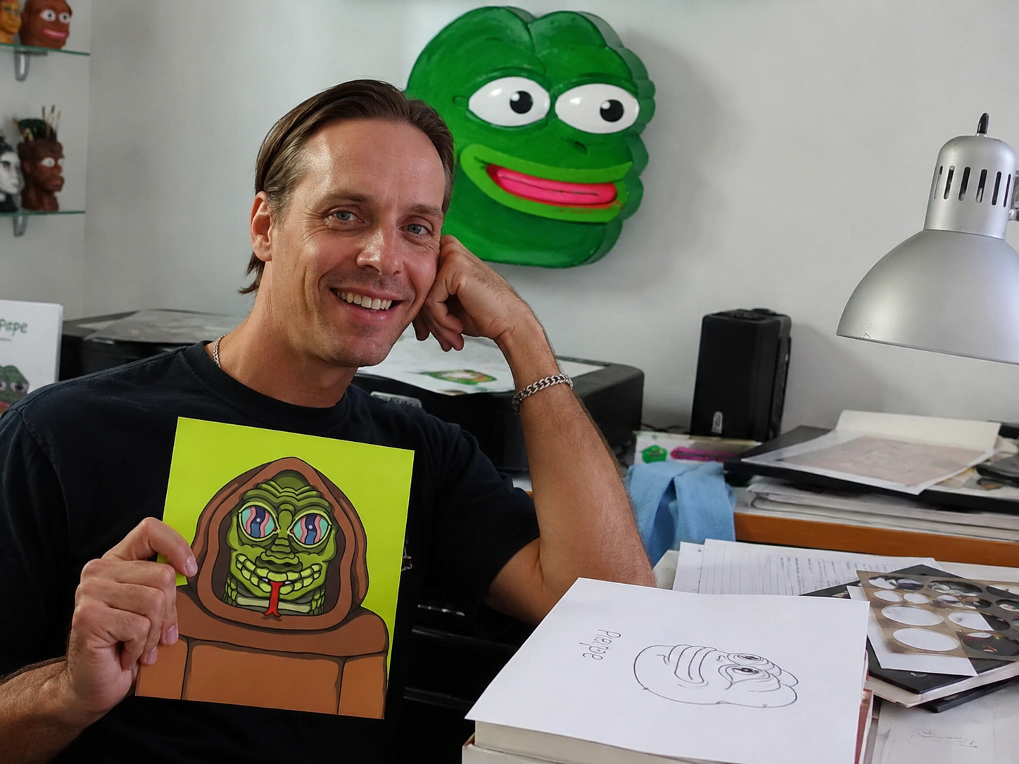 Artist holding Secret Lizard Hood art